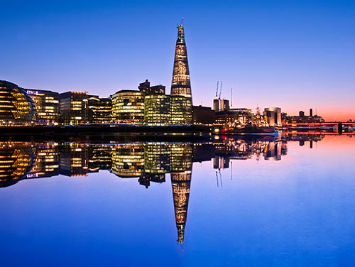 The Shard dominiert die Skyline von London bei Nacht.